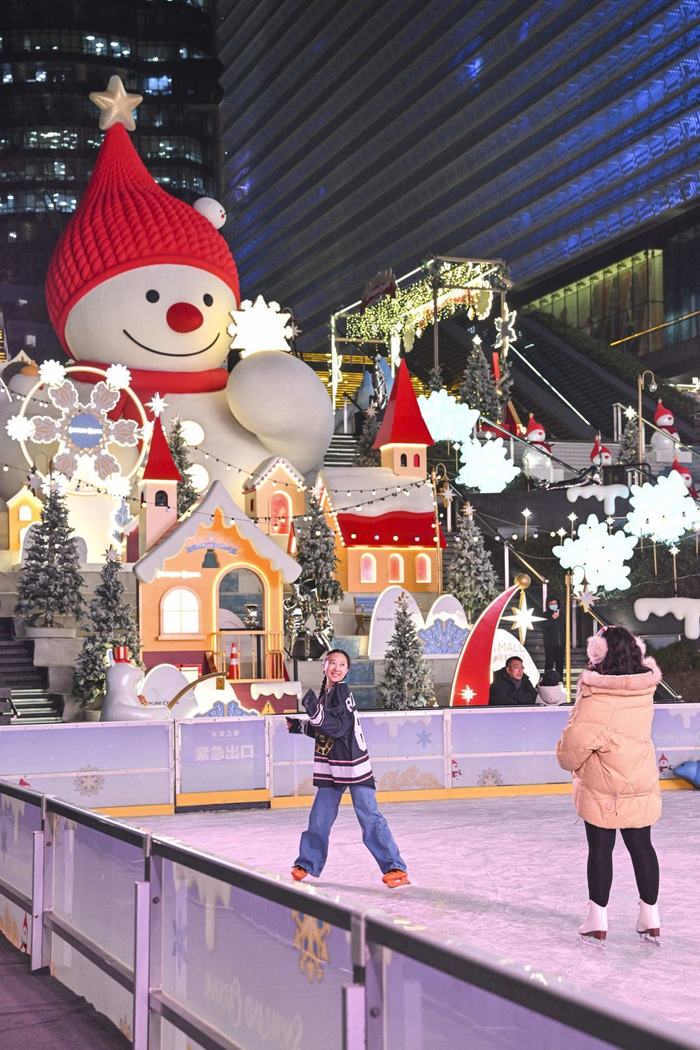 陆家嘴中心L+Mall下沉广场变身雪上乐园，都市楼宇与红帽雪人相映成趣