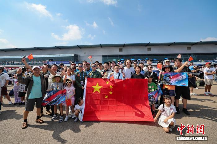 2月7日，中国空军八一飞行表演队在第十届新加坡航展上进行飞行表演。图为飞行员与观众合影。朱姜海 摄