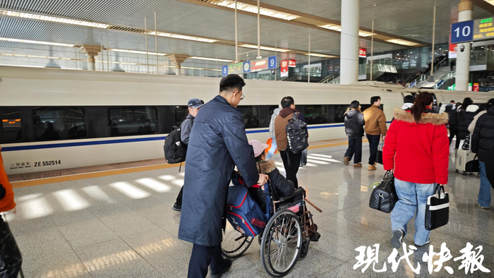 客运员徐浩送旅客出站