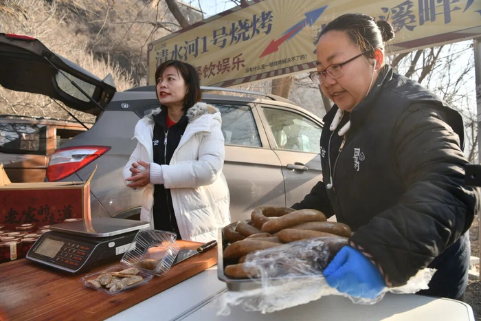 兴隆六道河集市上，商户正在自家摊位上摆放新鲜食材。