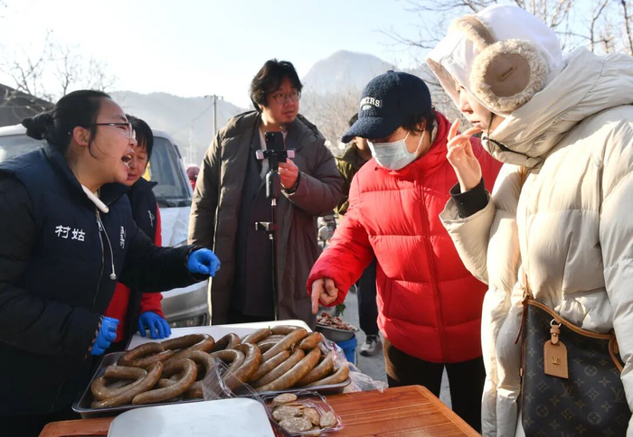 在集市上，游客正与摊主对话询问食材与口味。