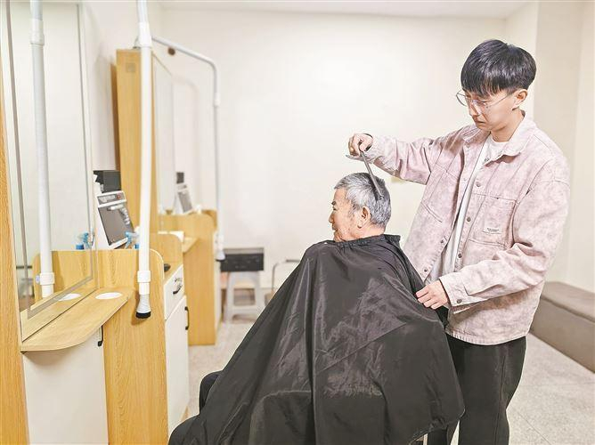 　　二楼是专属银发社交空间，棋牌室、理发室错落布局，65岁以上老人可免费预约理发。