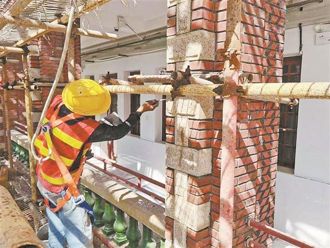 　　修缮人员在为黎明楼花岗石条石勾平缝。（修缮团队 供图）