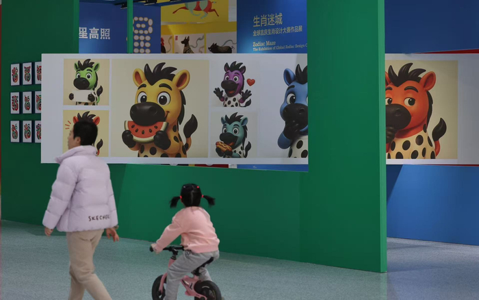 2月8日，北京通州站，一位带着孩子的市民在生肖设计作品展前通过。新京报记者 王贵彬 摄