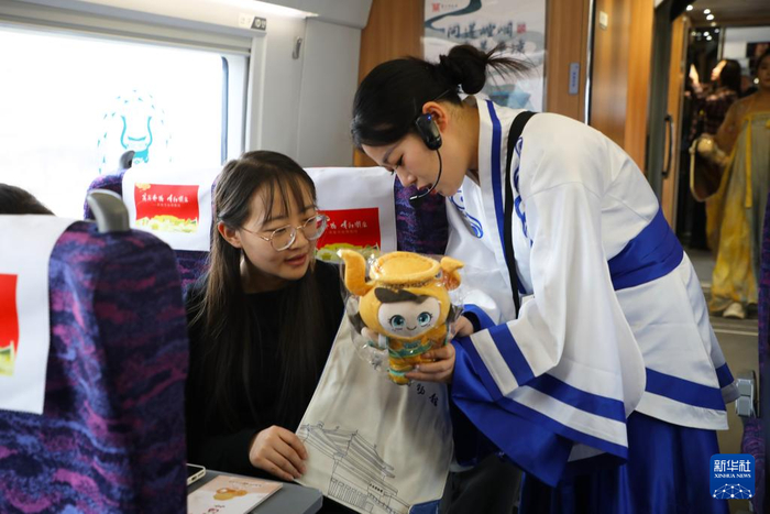   2月9日，在G848次列车上，敦煌研究院敦煌艺术馆工作人员向旅客介绍传统文化知识。新华社记者 张智敏 摄