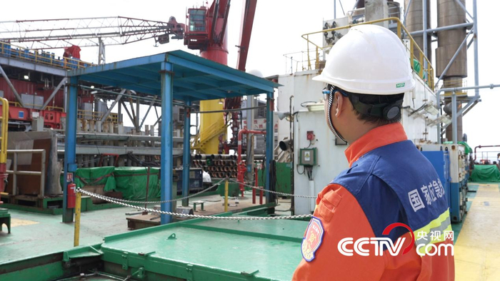 何连正在向记者介绍“奋进号”钻井平台 央视网记者隋佳桐 摄