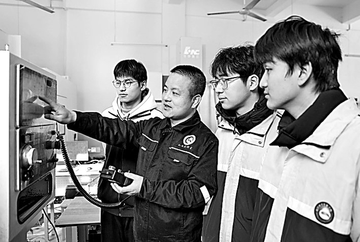 江西省瑞昌中等专业学校3D打印班，老师给学生讲解工业机器人的基本操作流程。魏东升摄/光明图片