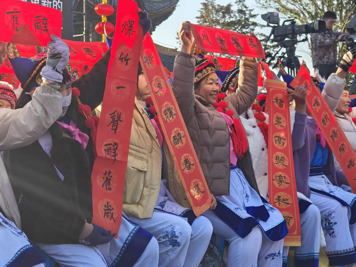 在场群众展示自己手中的春联。（张驰摄）