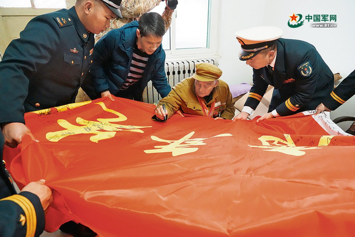 　　房来廷在荣誉战旗上签名。韩  亮摄