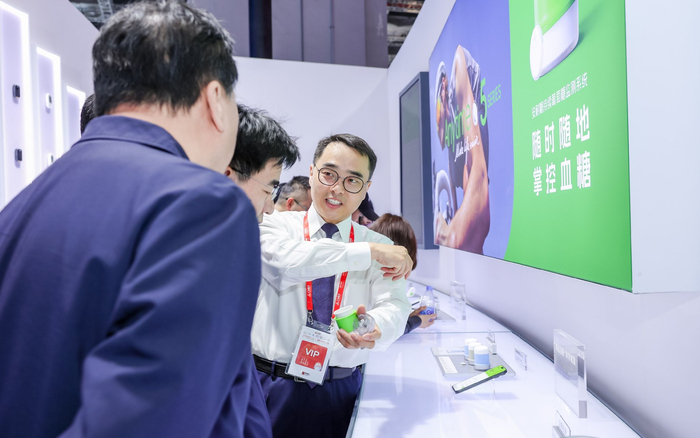 工作人员正向消费者介绍持续葡萄糖监测系统（CGM）。