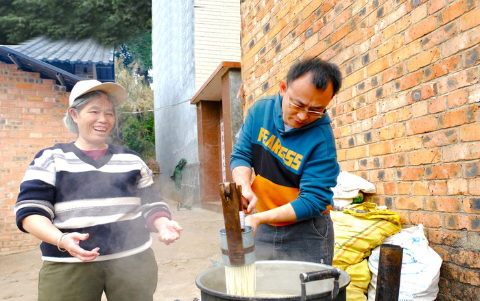     ▶黄家祝和母亲一起制作生榨米粉。    本报记者卢丽婷 摄