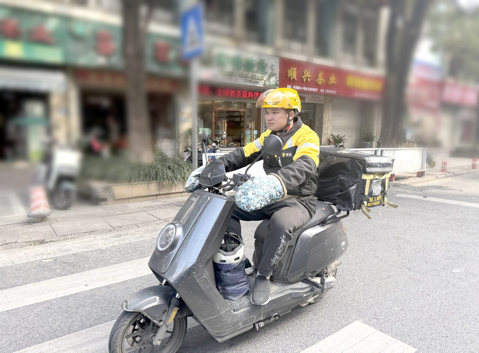     ◀春节将至，订单激增，外卖骑手陈新明奔波在送餐路上。    本报记者刘增璇 摄