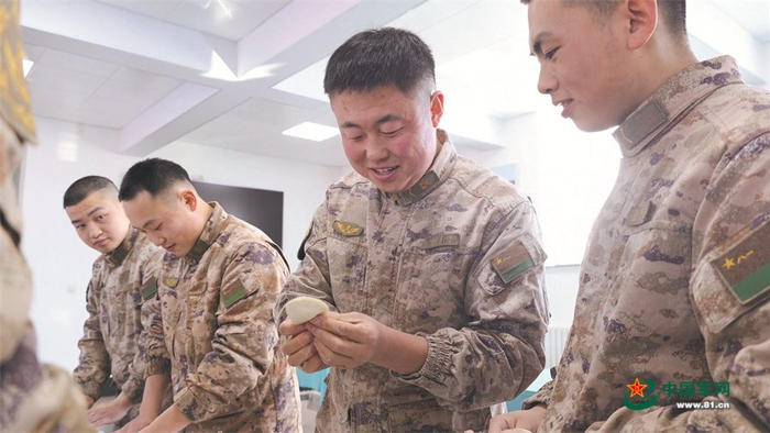 　　老兵利用业余时间教新兵包饺子。吴顺佳摄
