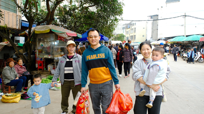     ▲黄家祝（前中）和家人逛邕宁区百济镇年圩，大包小包收获满满。