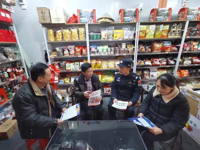 周梅初（左二）和民警一起向群众宣传法律知识