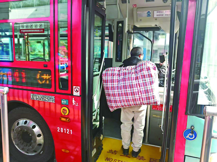     昨天，441路起点站，乘客背着行李上车。