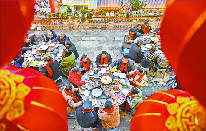     村民们欢聚一堂，共享热闹温暖的团年饭。