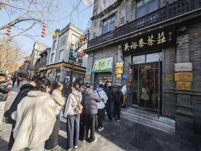 2月12日，吴裕泰前门店冰淇淋窗口吸引游人排队。 新京报记者 郭铁 摄