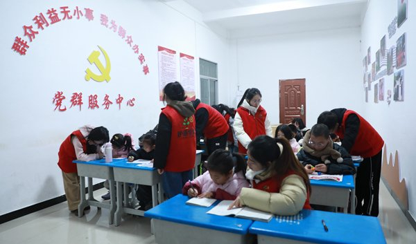 　　青年志愿者在“护苗学堂”辅导孩子们写寒假作业。王恩慧/摄