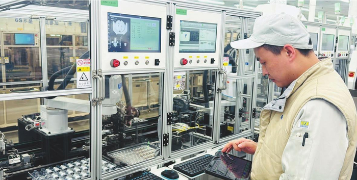     大连日佳电子车间里，技术工人向智能机器人输入指令。