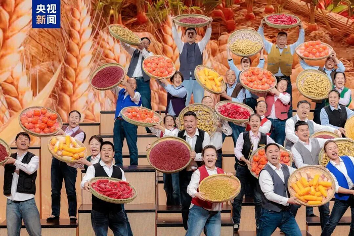 农民合唱团的乡亲们捧着沉甸甸的果实放声高歌。 图片来源：央视新闻