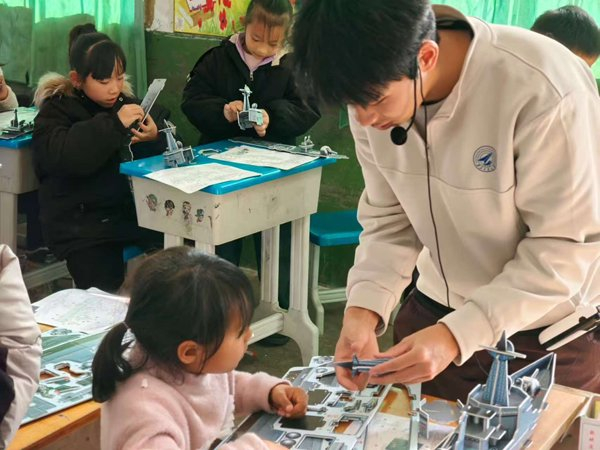 　　西北工业大学大学生志愿者带领孩子们制作航模。（西北工业大学供图）