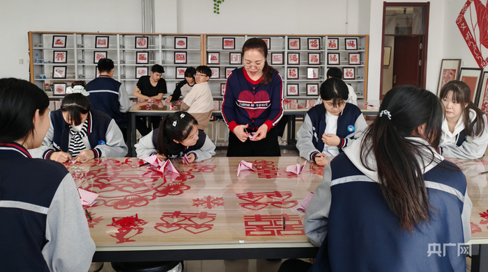 胡颖在教学生们剪纸（央广网发  毕乐陶  摄）