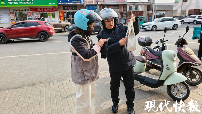 记者与靖艾花一起在小镇上送外卖