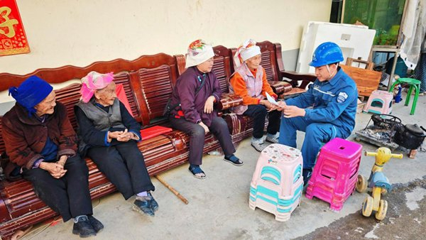 （广南供电局那洒供电所工作人员向老人讲解用电知识。韦银荧/摄）