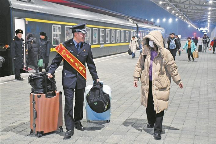     2月13日，乌鲁木齐铁路公安局奎屯公安处北屯站派出所民警（左一）帮助旅客拿行李。兵团日报常驻记者  李正虎  通讯员  赵江明  摄