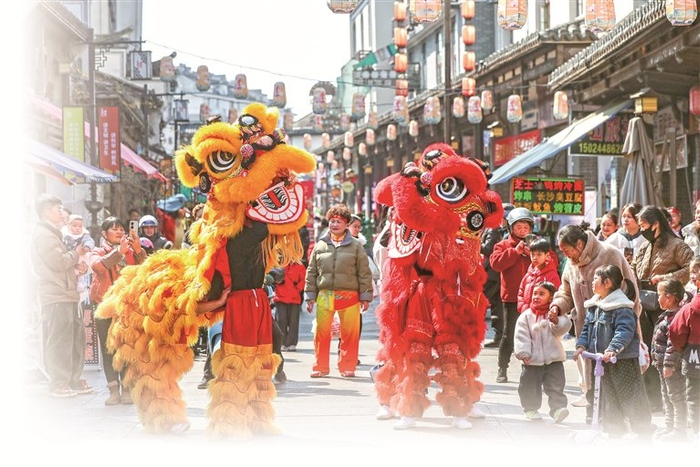 在浙江省建德市寿昌古镇老街上，游客们观看传统舞狮表演。新华社记者 徐昱 摄