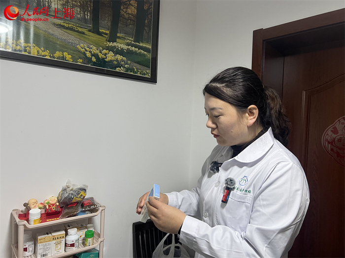 护理员赵听听帮老人查看药物有效期。人民网记者葛俊俊摄