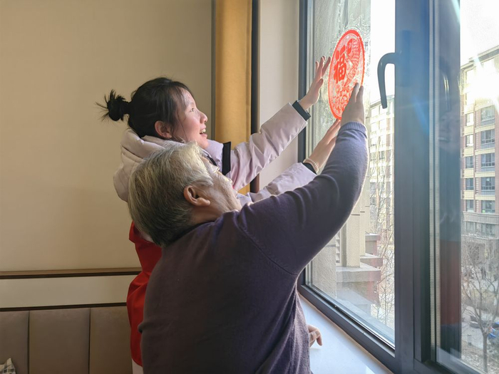 南文营社区工作者申彤欣来到独居老人马淑仙家中贴春联和福字。新华社记者 苏凯洋 摄