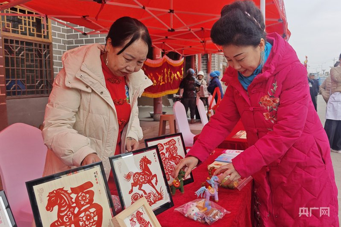写春联、买剪纸，集市上的喜庆年味藏不住（央广网记者  汪晓青  摄）