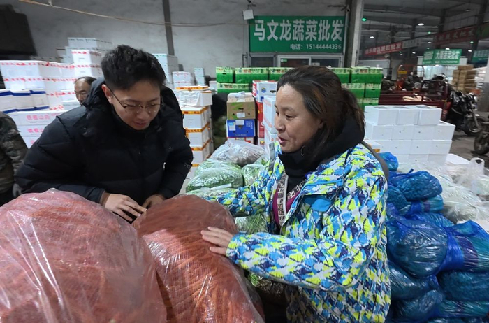 朱微微（右一）在万邦农副产品批发市场挑选蔬菜。新华社记者司晓帅 摄
