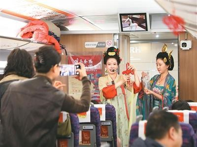 2月9日，在G848次列车上，敦煌研究院敦煌艺术馆工作人员向旅客讲解传统文化知识。新华社记者 张智敏摄