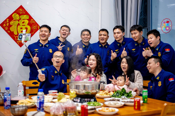 2月16日，在江苏省泰兴市澄江西路消防救援站，消防员们和家属在吃团圆饭前合影。杨玉岗摄