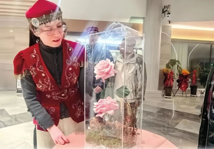 ·蔡艳飞与“娇龙”月季合影。（新华社）