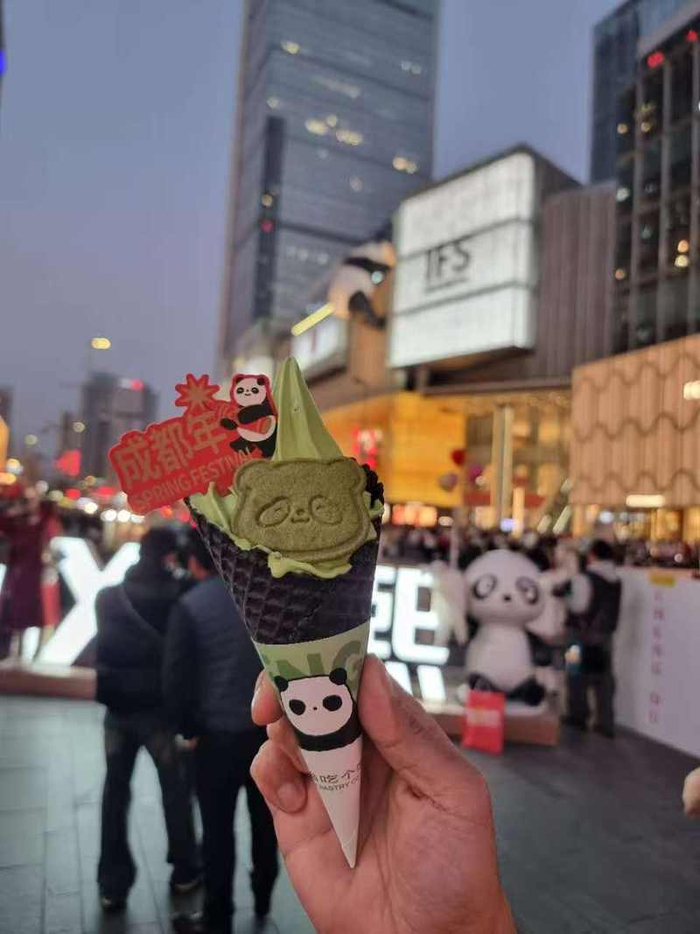  成都春熙路商圈，Jose拍摄的熊猫甜筒冰淇淋，背景是“爬墙大熊猫”。受访者供图