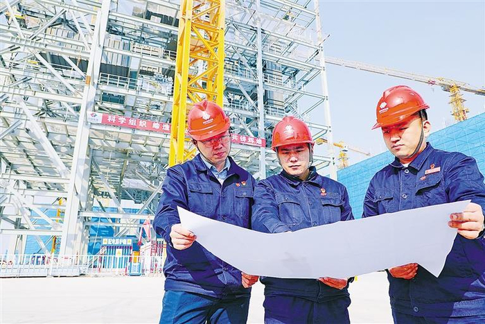     图为工程人员现场核验施工设计图纸。    本报记者 刘向 摄