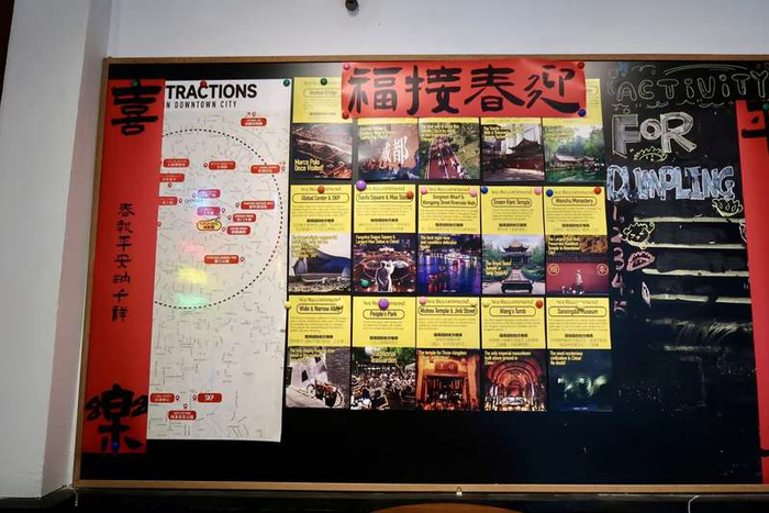  拖板鞋青年旅舍，黑板上张贴着对联和双语景点介绍。新京报记者 吴淋姝 摄