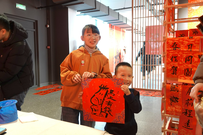 市民游客拿到心仪的对联和文字（央广网记者  郭明彤  摄）