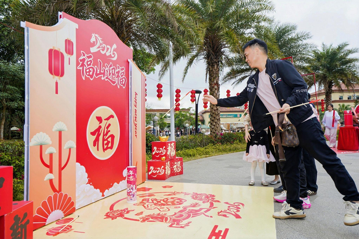 2月17日，游客在澄迈福山咖啡文化风情镇参与互动游戏。