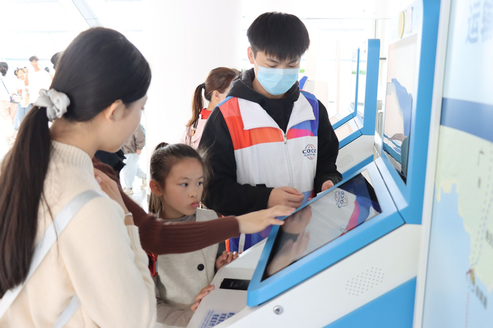 图为2月17日大年初一，志愿者在海口新海港综合客运枢纽为出行旅客服务。