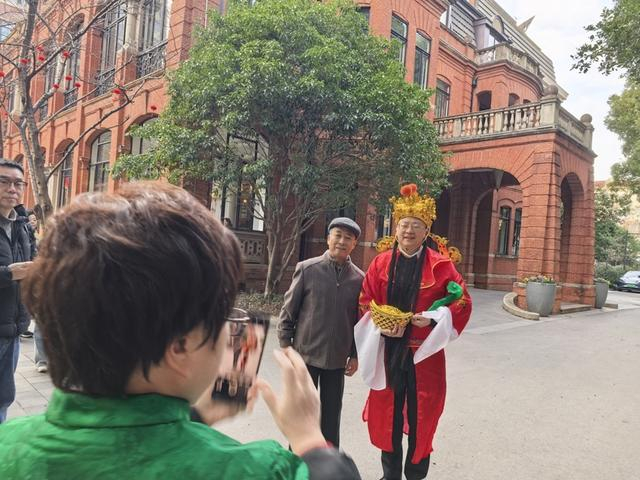 瑞金宾馆住客和财神装扮的导览员合影。 李宝花 摄