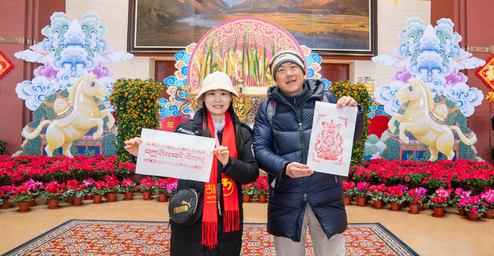2月17日，市民游客在西藏博物馆领取木刻印刷的“扎西德勒”（左）和吉祥八宝之一“金鱼”（右）图。记者 欧珠次仁 摄