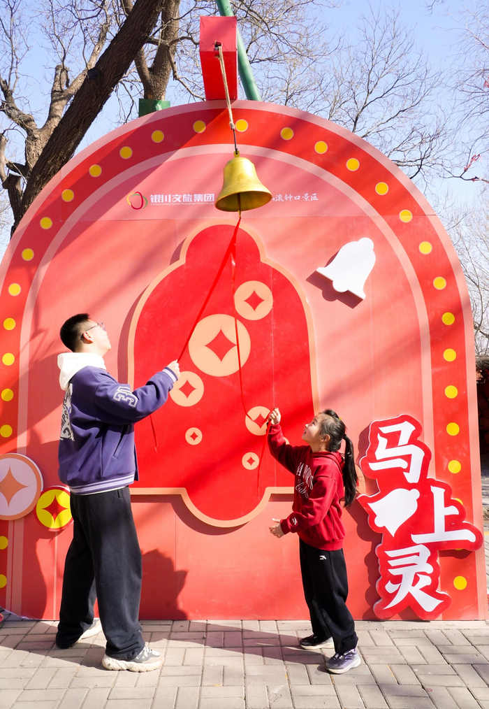 红绸缠绕的新年发财铃被游客依次敲响。