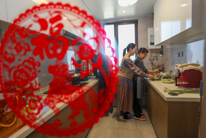 中午时间，牛佩瑶（右二）和父母一起在雄安家中的厨房做午饭。人民日报记者 张武军摄