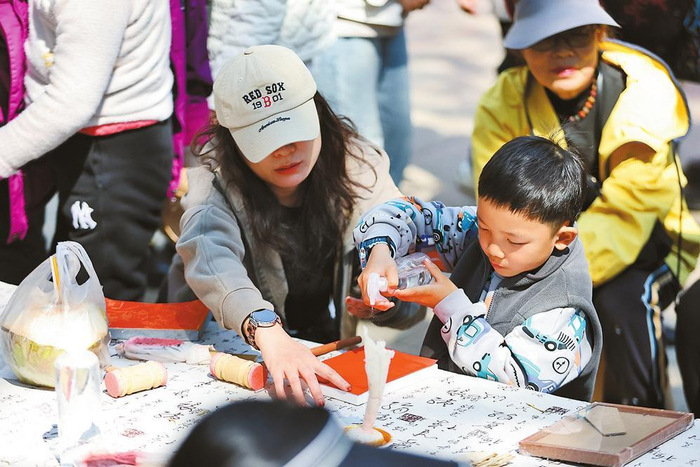 大年初二，游客在昆明金殿庙会上体验非遗技艺。记者 陈飞 摄