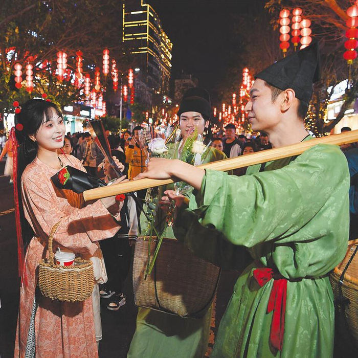 海口府城换花活动现场，身穿国风服装的演员在街头与市民游客互动。龙泉 摄